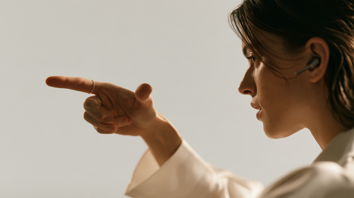 A ring-wearing hand makes a deliberate pointing gesture.